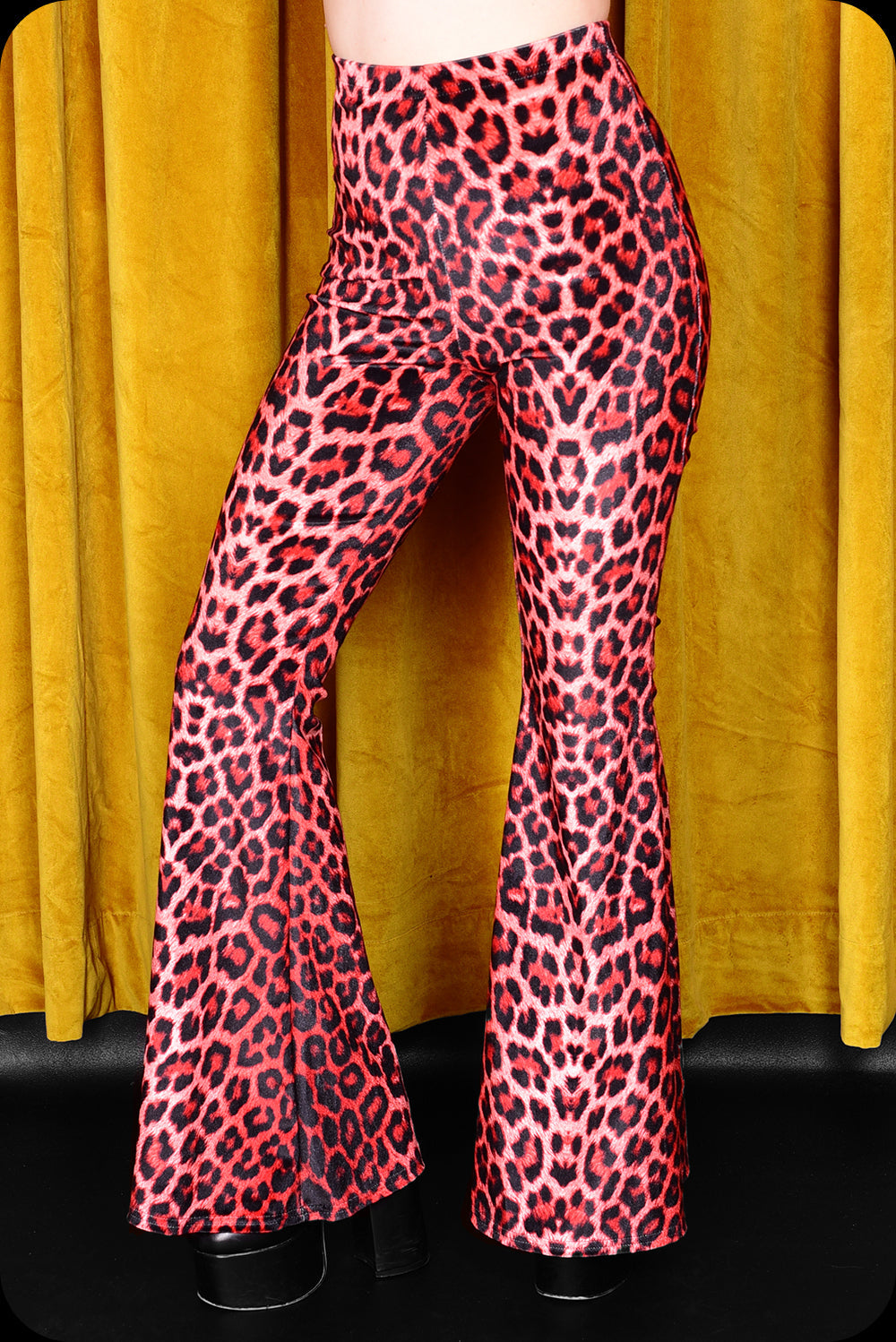 A pair of red leopard print velvet bell bottom trousers by Scorpio Rising